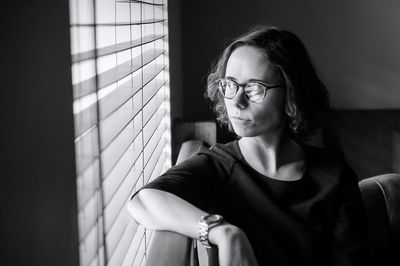 Portrait of young woman sitting on wall at home