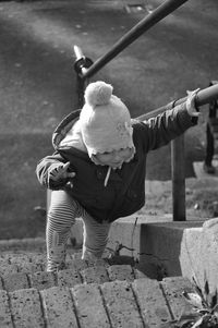 High angle view of boy climbing steps at park