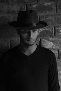 Portrait of young man standing against wall