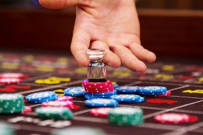 Cropped hand of man playing with gambling chip