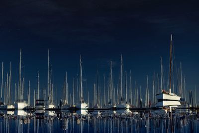 Boats moored in harbor at night