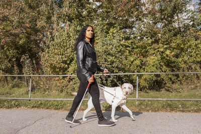 Visually impaired woman walking with guide dog