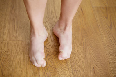 Low section of person on hardwood floor