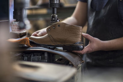 Shoemaker working on shoe in workshop