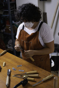 Wood craftswoman with mask sharpening tool with stone