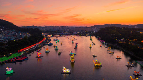 High angle view of river amidst buildings in city at sunset