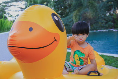 Portrait of cute boy sitting on inflatable ring