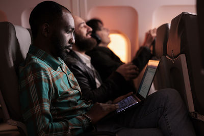 Rear view of man using laptop