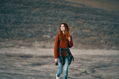 Portrait of smiling young woman standing on land