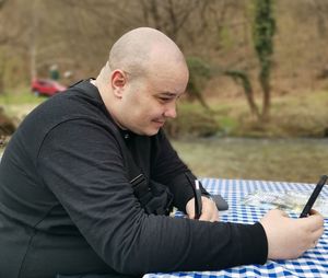 Midsection of man using mobile phone