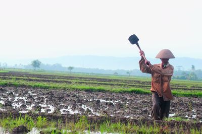 Man working on farm against sky