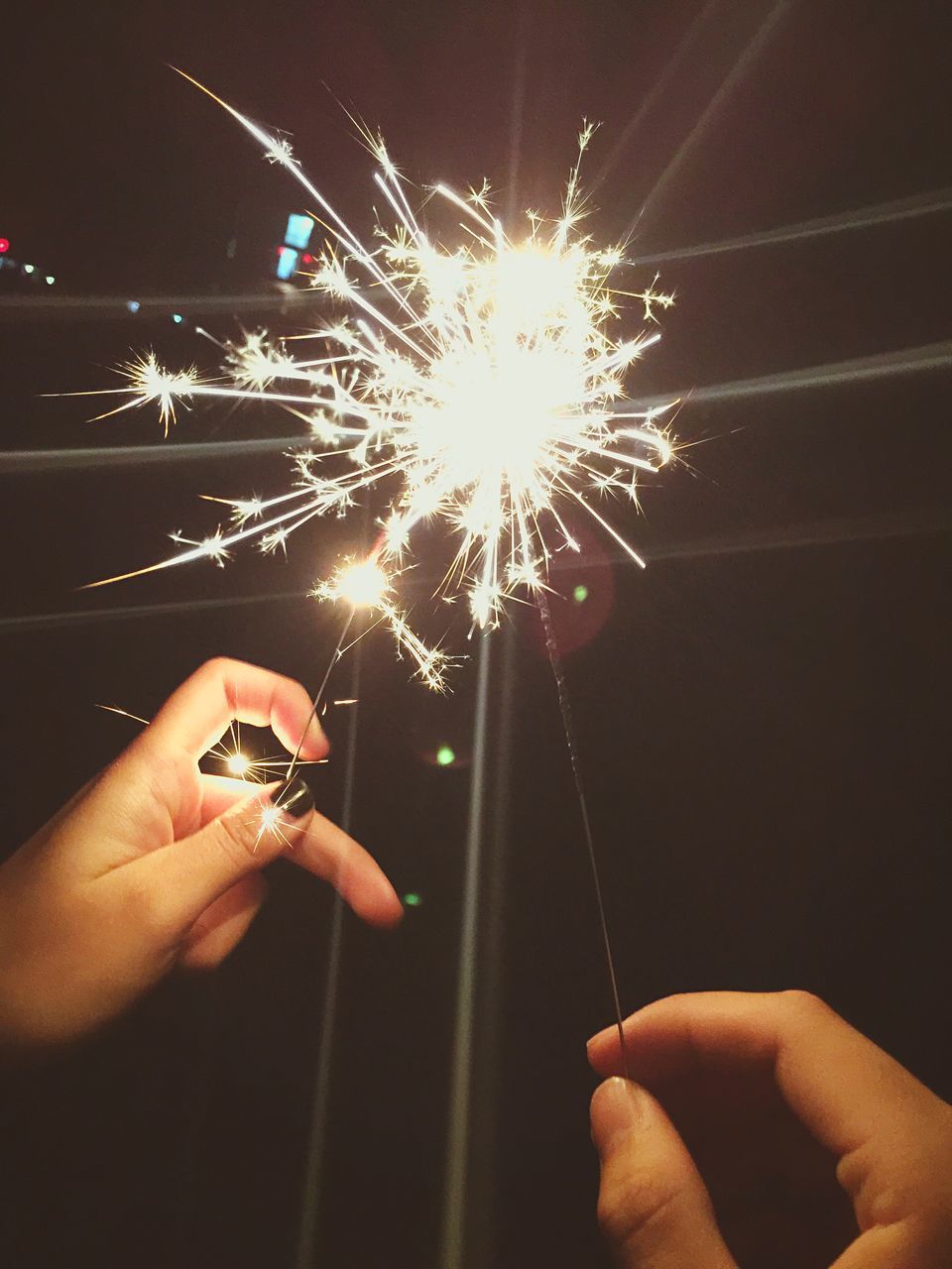 human hand, holding, one person, human body part, sparks, human finger, real people, firework - man made object, celebration, sparkler, burning, long exposure, motion, unrecognizable person, illuminated, firework display, leisure activity, enjoyment, close-up, night, lifestyles, firework, playing, outdoors, sky, people