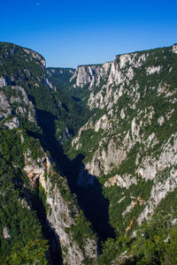 Scenic view of mountains against clear blue sky