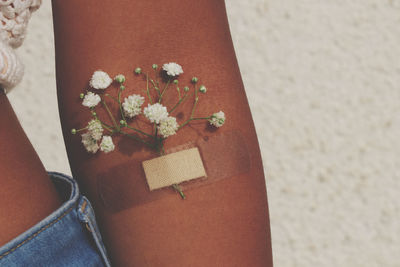 Close-up of flowers stuck with bandage on hand