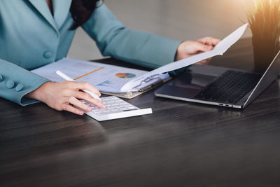 Midsection of businessman working at table