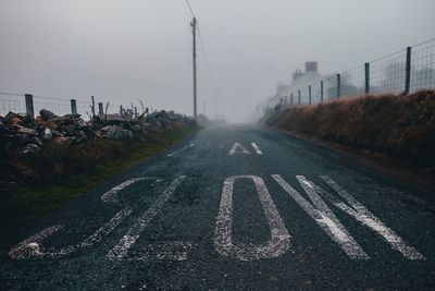 Text on road in city during foggy weather