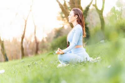 Side view of woman sitting on field