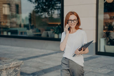 Young woman using mobile phone in city