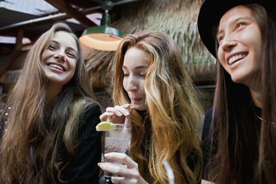 Happy young friends enjoying drinks at a bar