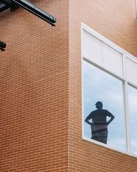 Low angle view of electric lamp on wall of building