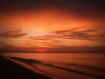 Scenic view of sea against dramatic sky during sunset