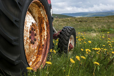 Close-up of tire on field against sky