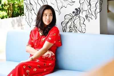 Portrait of beautiful young woman sitting on sofa