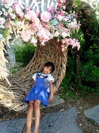 Portrait of woman on flowering plants against trees