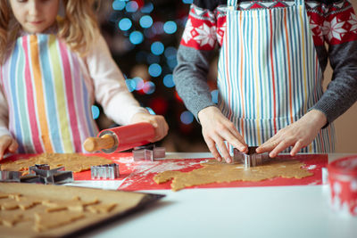 Rear view of mother and daughter on table