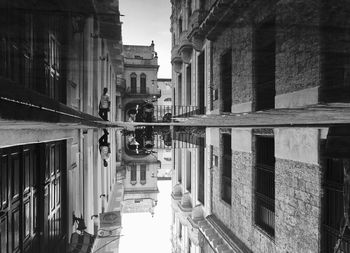 Man reflecting in puddle amidst buildings