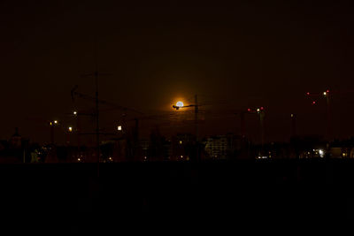 Illuminated buildings against sky at night