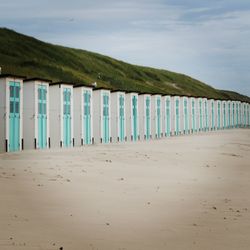 Wooden posts on beach against sky