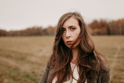 Sad girl with blue eyes. portrait of a girl in brown tones. walk through the woods. autumn colors.