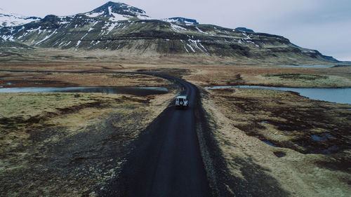 Road by mountain against sky