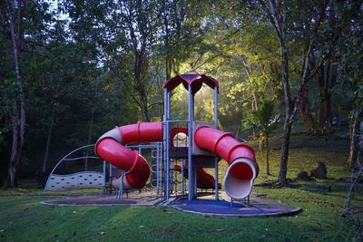 Empty playground against trees in park