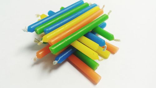 High angle view of multi colored pencils on white background