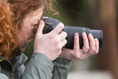 Portrait of woman photographing through smart phone