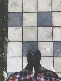 Low section of man standing on cobblestone