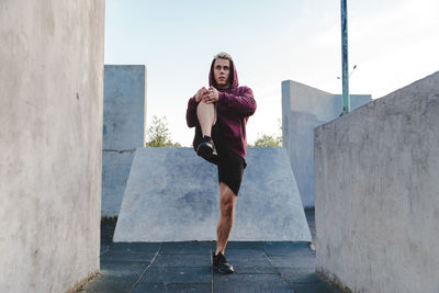 Full length portrait of woman against wall