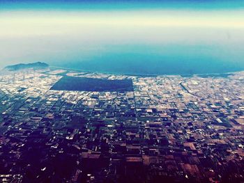 Aerial view of city against cloudy sky