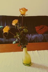 Close-up of yellow flower vase on table at home