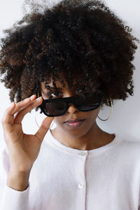 Beautiful black woman with afro hair wearing futuristic video recording glasses