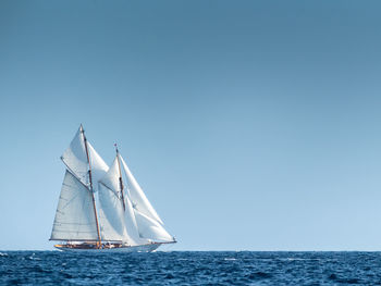 Sailboat sailing in sea against clear sky