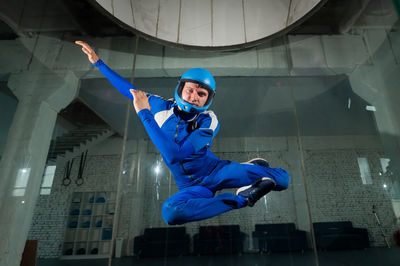 Low angle view of young man jumping against wall