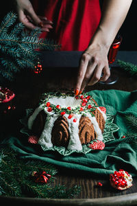 Gingerbread bundt cake for christmas with pomegranate and christmas decorations over dark background