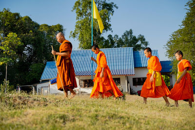 People standing on field against sky