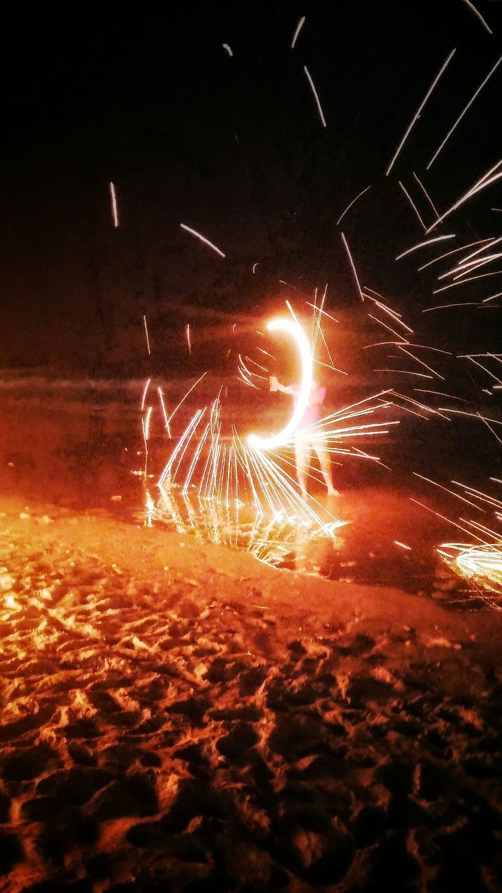 night, illuminated, long exposure, glowing, motion, firework display, exploding, lens flare, blurred motion, sparks, low angle view, firework - man made object, light trail, outdoors, sky, light - natural phenomenon, no people, sunbeam, street, sun