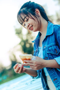 Portrait of a smiling young woman holding ice cream