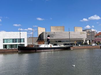 Buildings by river against sky