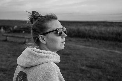 Side view of woman looking away on field